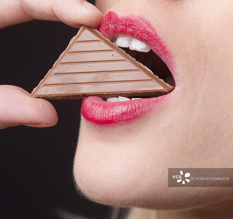 女人手拿一块巧克力图片素材