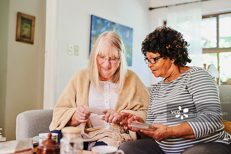 两位中年女性朋友一起翻看旧照片的照片图片素材