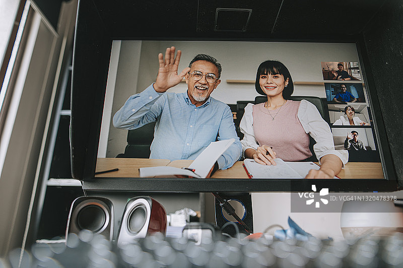 居家桌面电脑屏幕上显示的亚洲同事视频会议图片素材