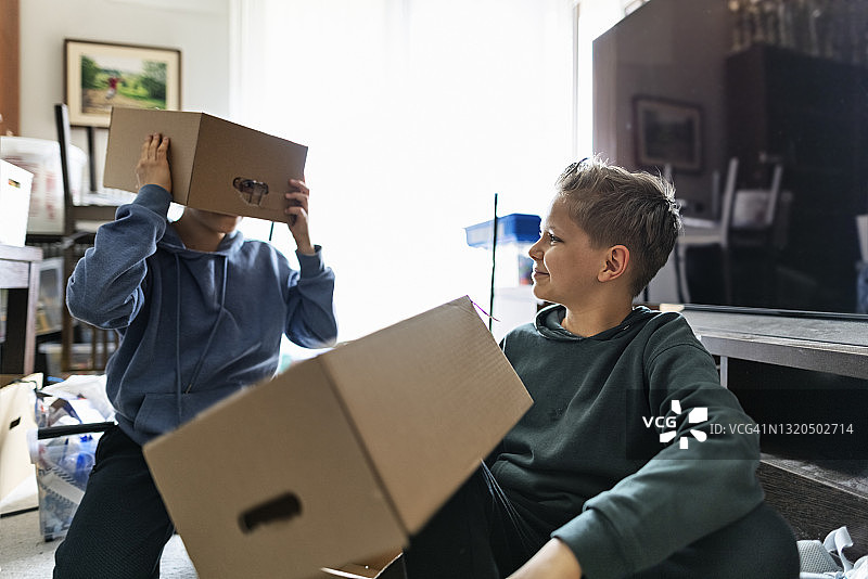搬家时玩纸箱的两个男孩图片素材