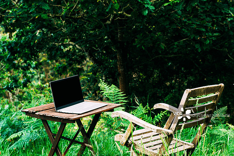 花园里的桌椅和笔记本电脑图片素材