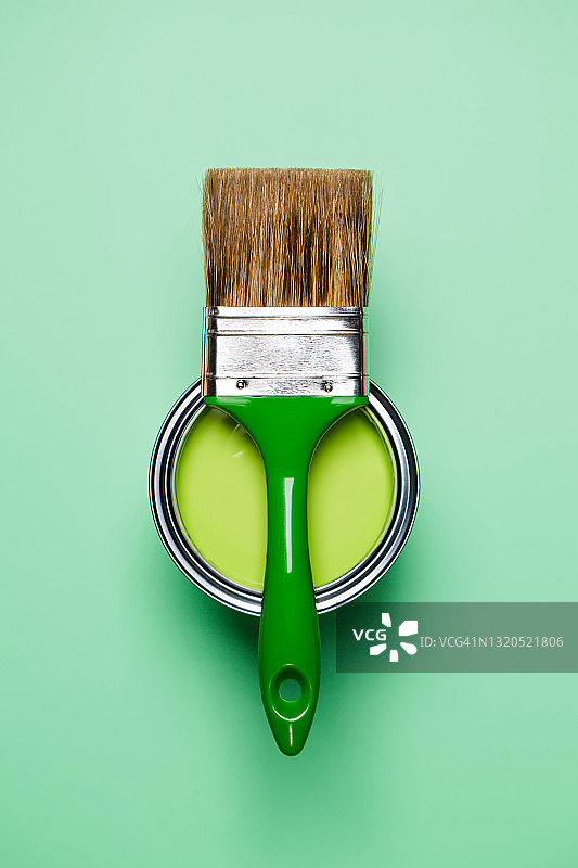用于翻新工程的干净油漆刷和绿色油漆桶，浅绿色背景，扁平风格，家居室内重新装修概念，设计配色样本，留有设计空间图片素材