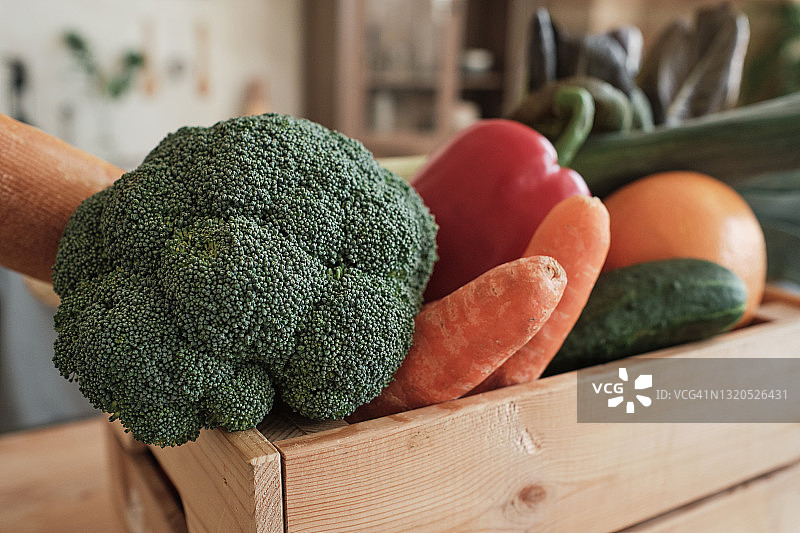 木箱中西兰花、胡萝卜、黄瓜和甜椒等新鲜蔬菜的特写图片素材
