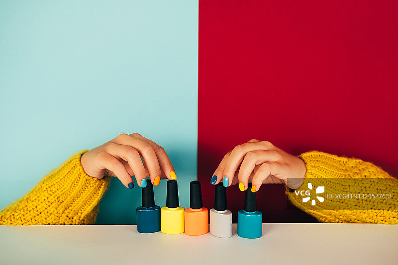 涂着黄色指甲油的女人手持玻璃瓶图片素材