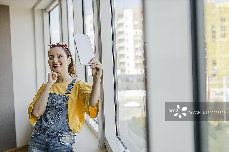 漂亮的女人在新公寓里用平板电脑进行视频通话图片素材