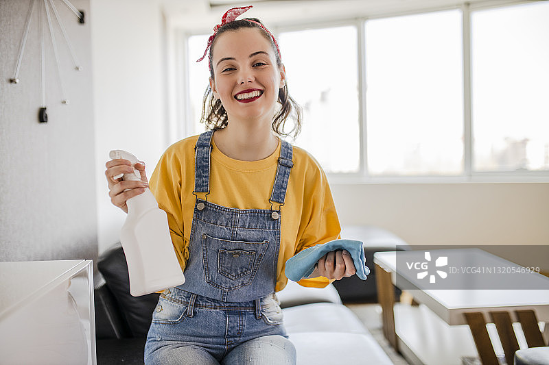 女人擦拭客厅架子和其他家具上的灰尘图片素材