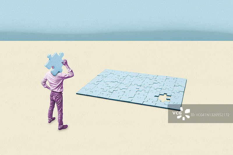 男人手持最后一块拼图图片素材