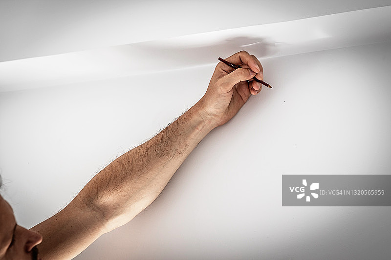 水电工在墙上用铅笔标记钻孔位置特写图片素材