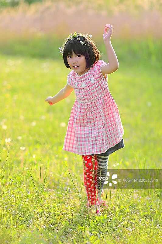在草地上跳舞微笑的小女孩图片素材