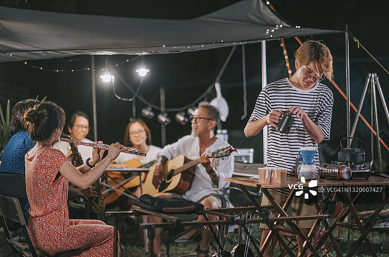 中国少年在花园派对上制作滴漏咖啡，朋友们演奏乐器图片素材