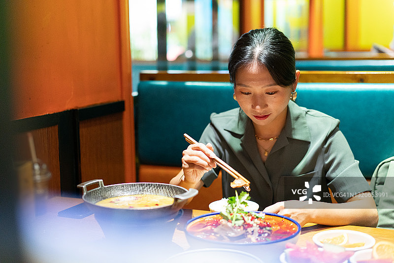 独自用餐的年轻有魅力的亚洲女性图片素材