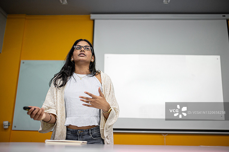 亚洲大学生在投影幕布前做展示图片素材