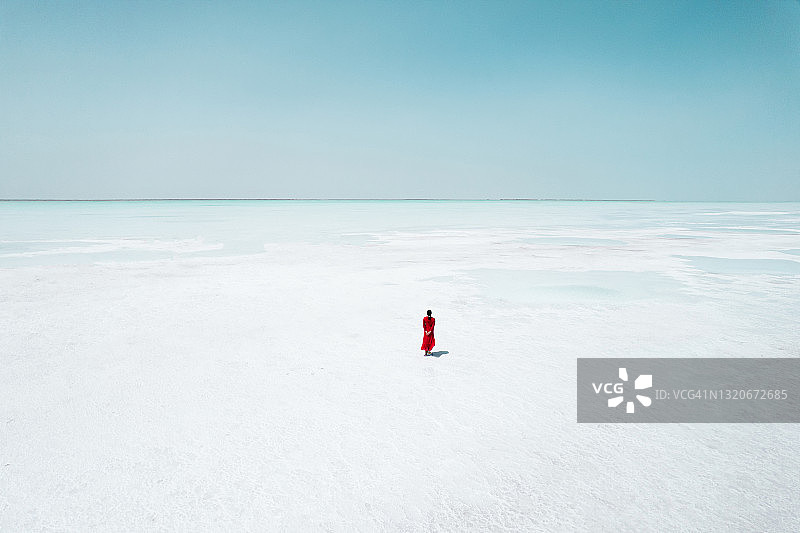 航拍穿红裙的女人在盐湖上行走图片素材