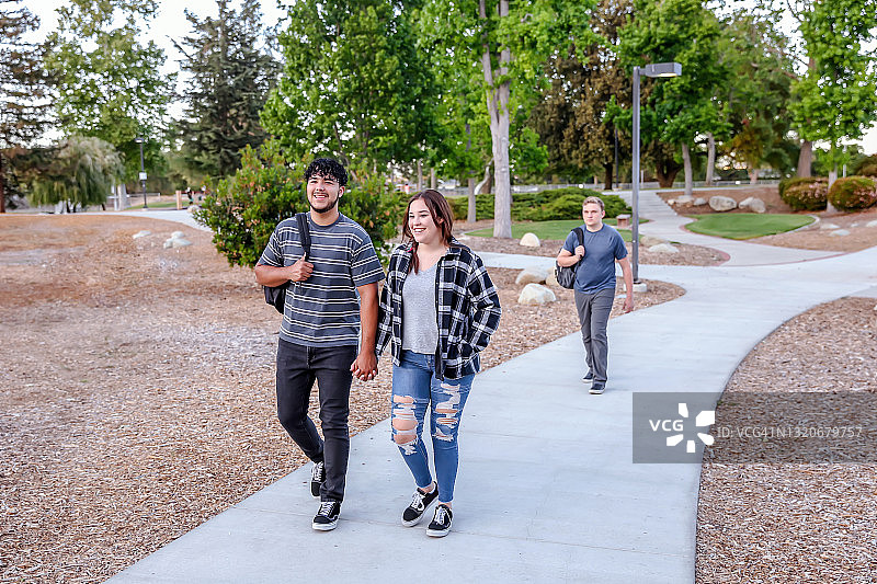 三名大学生在校园里行走图片素材