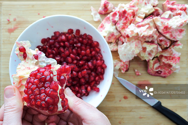从石榴果中取出石榴籽的人图片素材
