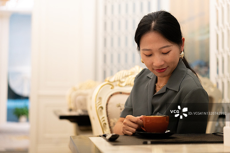 年轻亚洲女人喝咖啡图片素材