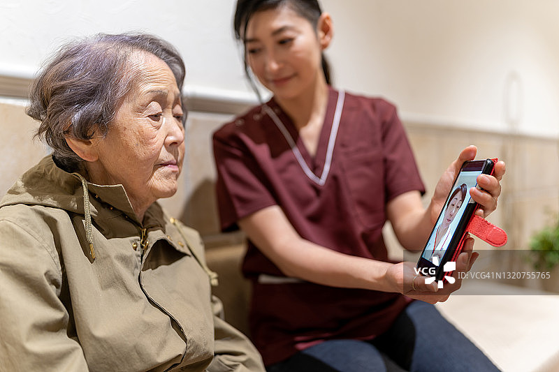 亚洲老年人和护理人员的远程医疗图片素材