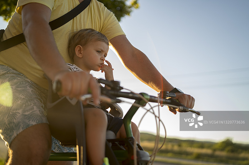 父亲用儿童座椅带着儿子骑自行车图片素材