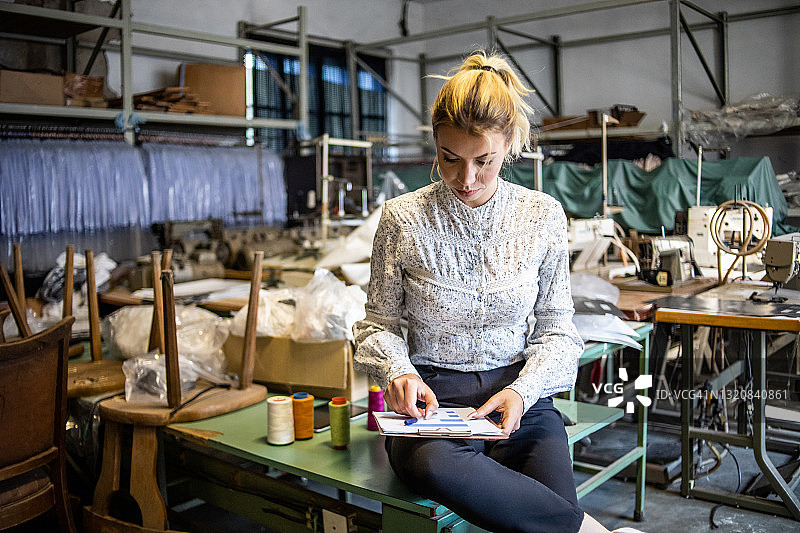 在时尚行业仓库工作的年轻女子图片素材