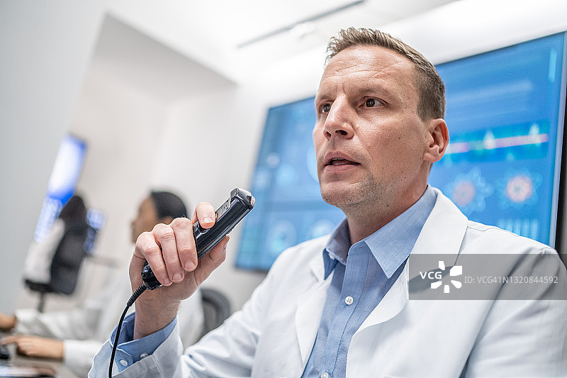 医生使用专业录音设备记录报告图片素材