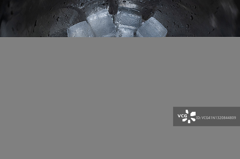 冰桶的鸟瞰图。金属容器底部有几块融化的冰块图片素材