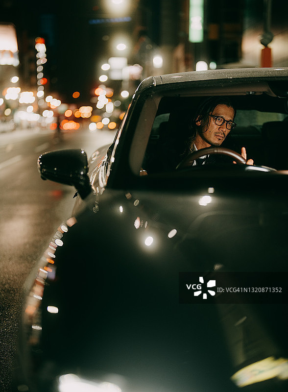 夜晚东京街头，车内等待的男子图片素材
