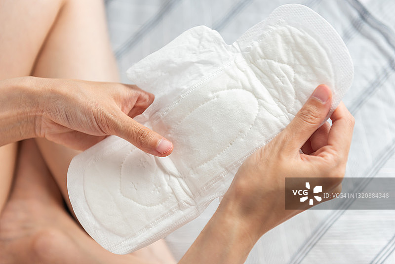 特写：女子手持白色卫生巾图片素材