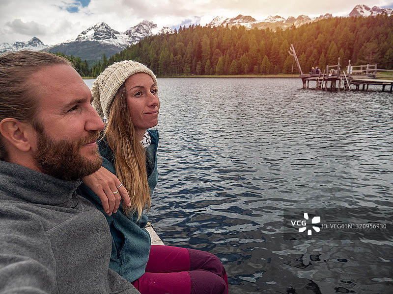 日落时湖边码头休闲的夫妻图片素材