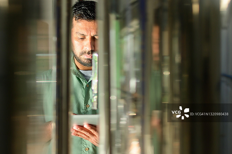 车间内使用无线设备的制造业工人图片素材