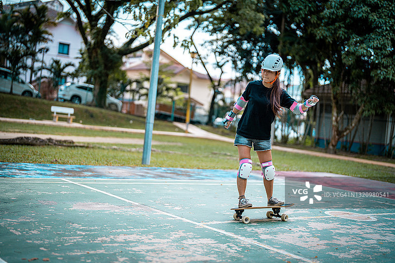 女孩在公园玩滑板图片素材