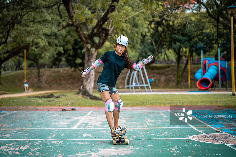女孩在公园玩滑板图片素材