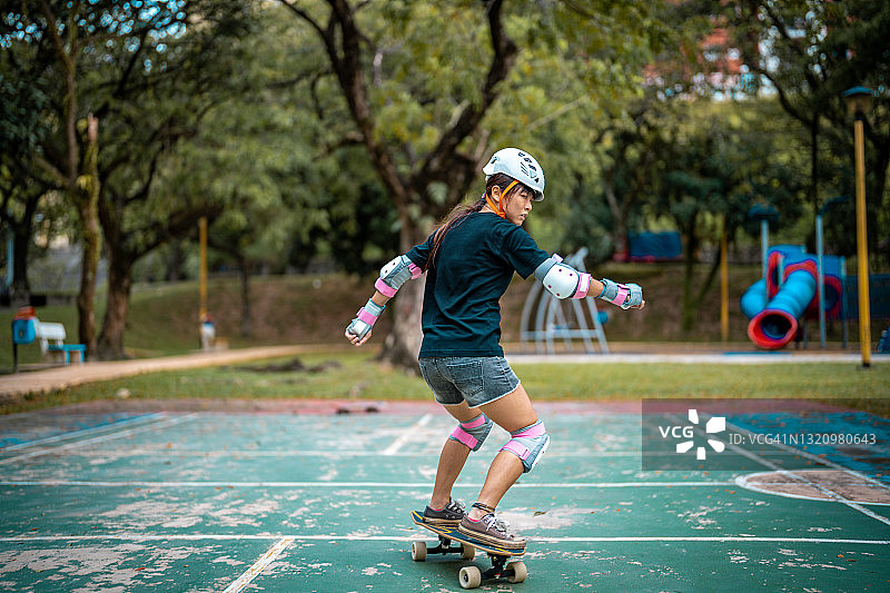 女孩在公园玩滑板图片素材