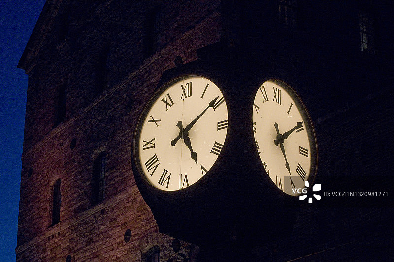 夜晚建筑旁的四面户外街钟图片素材