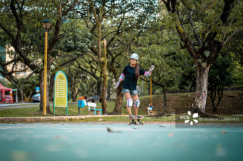 女孩在公园玩滑板图片素材