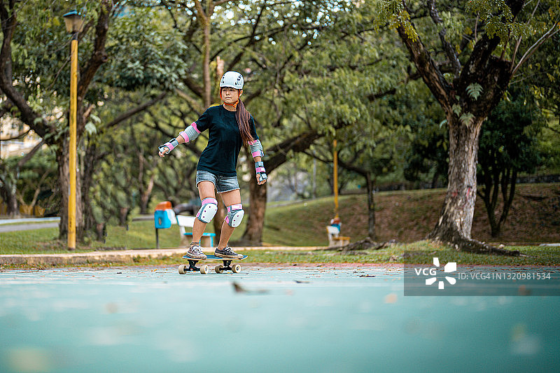 女孩在公园玩滑板图片素材