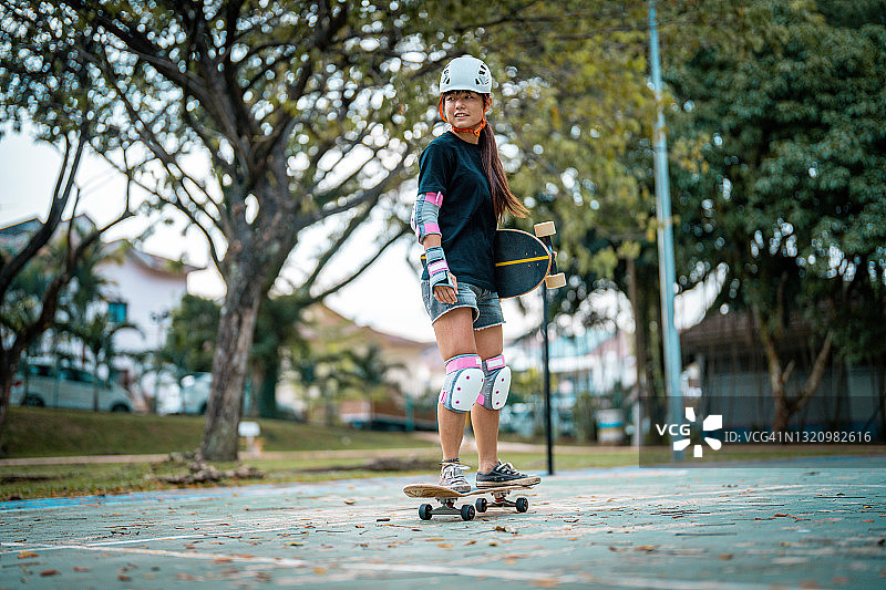 女孩在公园玩滑板图片素材