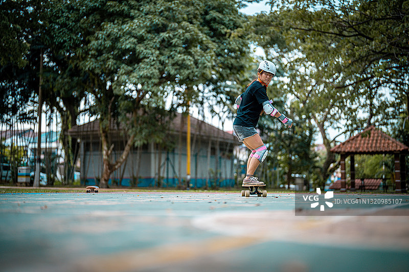 女孩在公园玩滑板图片素材