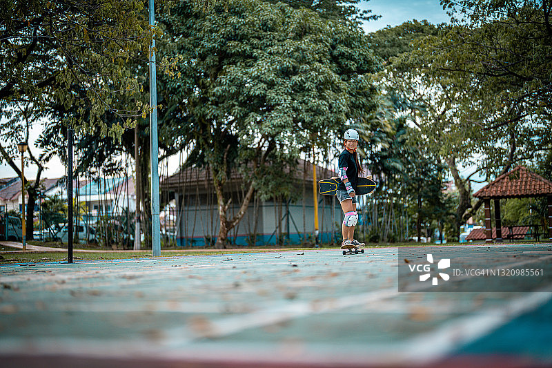 女孩在公园玩滑板图片素材