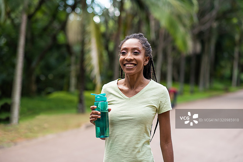 跑步的女人拿着一瓶水图片素材