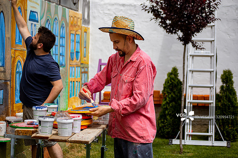 两位艺术家绘制墙壁壁画图片素材