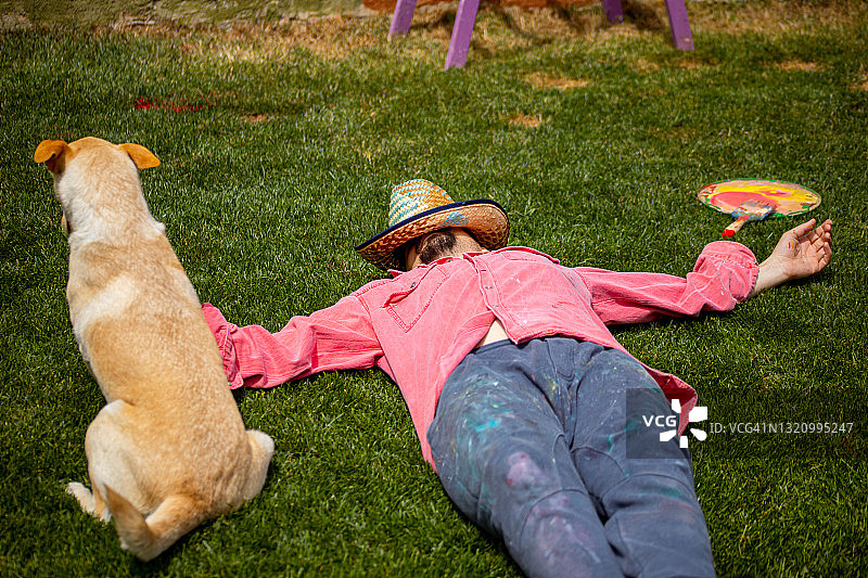 画家和他的狗在草地上睡觉图片素材