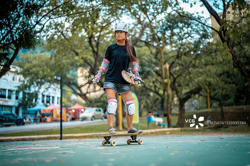 女孩在公园玩滑板图片素材