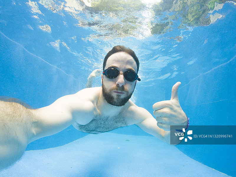 男人在泳池里跳水图片素材