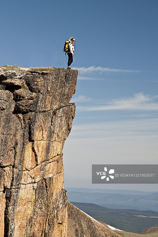 站在悬崖边上健康健美的女性背包客图片素材