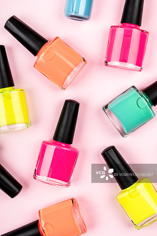 粉色背景上明亮的多彩指甲油（竖版）图片素材