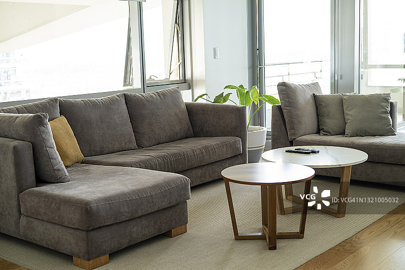 白天带有灰色沙发和北欧咖啡桌的现代客厅图片素材