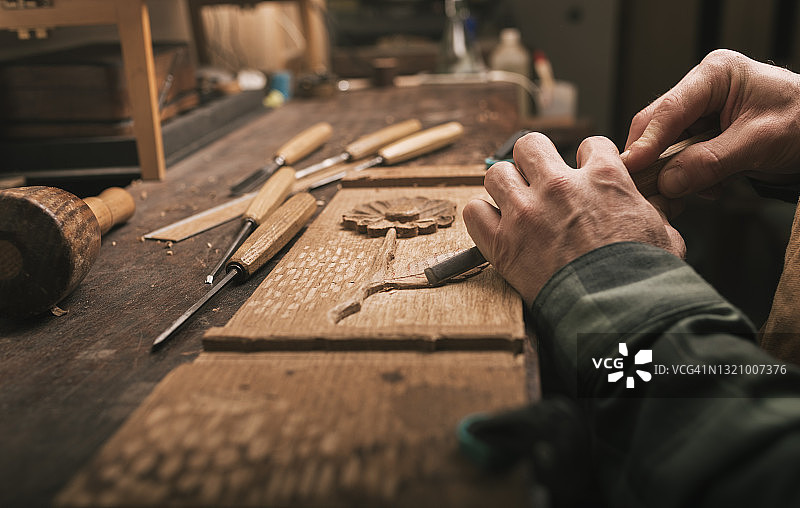 细木工匠用凿子进行木雕的特写图片素材