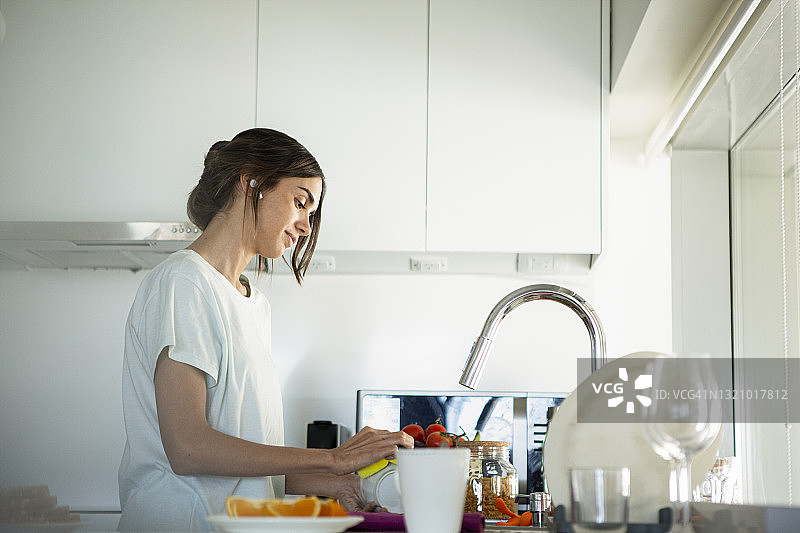 年轻女子在厨房洗碗图片素材