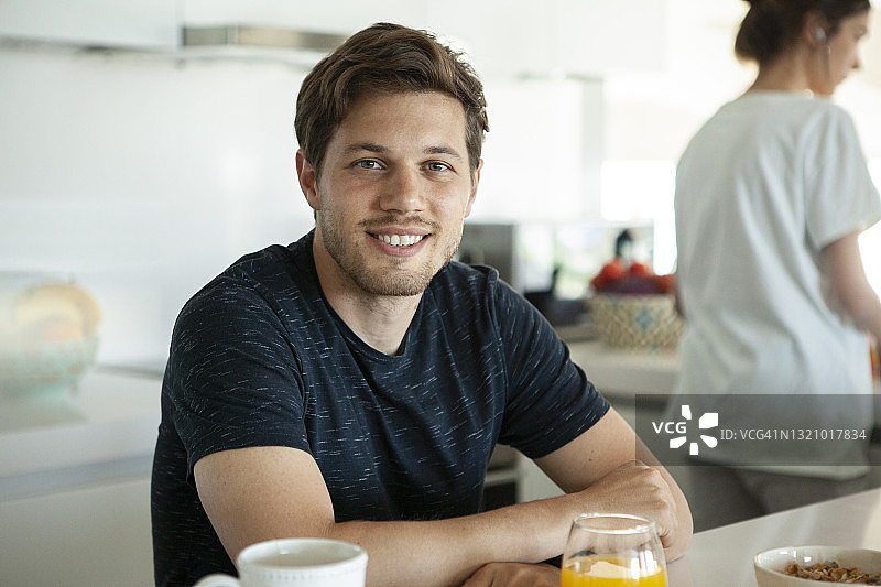 男人坐在厨房里看向镜头图片素材