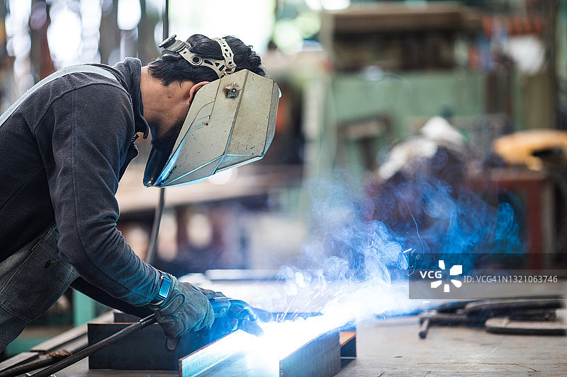 工厂里焊接钢铁的金属工人图片素材